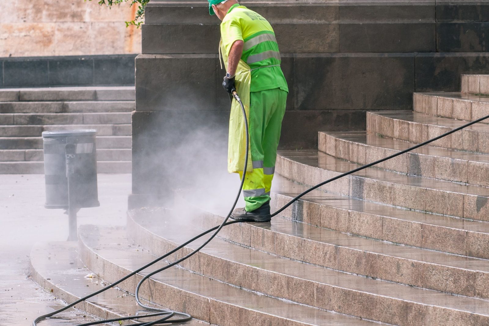 Worker pressure washing stone steps, an example of the exterior cleaning we do