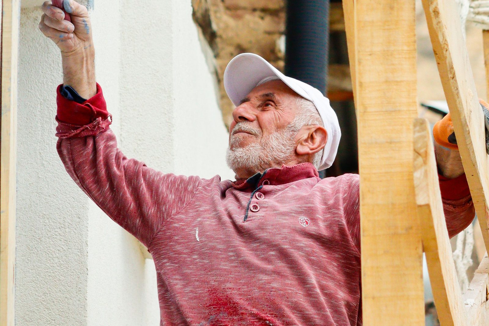 Carpenter repairing an exterior wall, an example of the repair work we do
